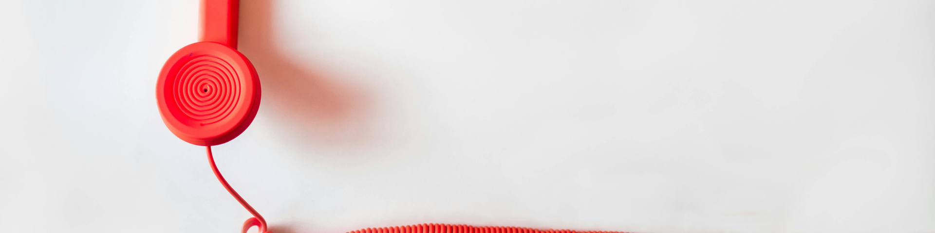 A red telephone receiver and cord